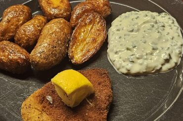 Schnitzel, accompanied by fried potatoes and a homemade chive-based sourcream sauce as a dip with the potatoes