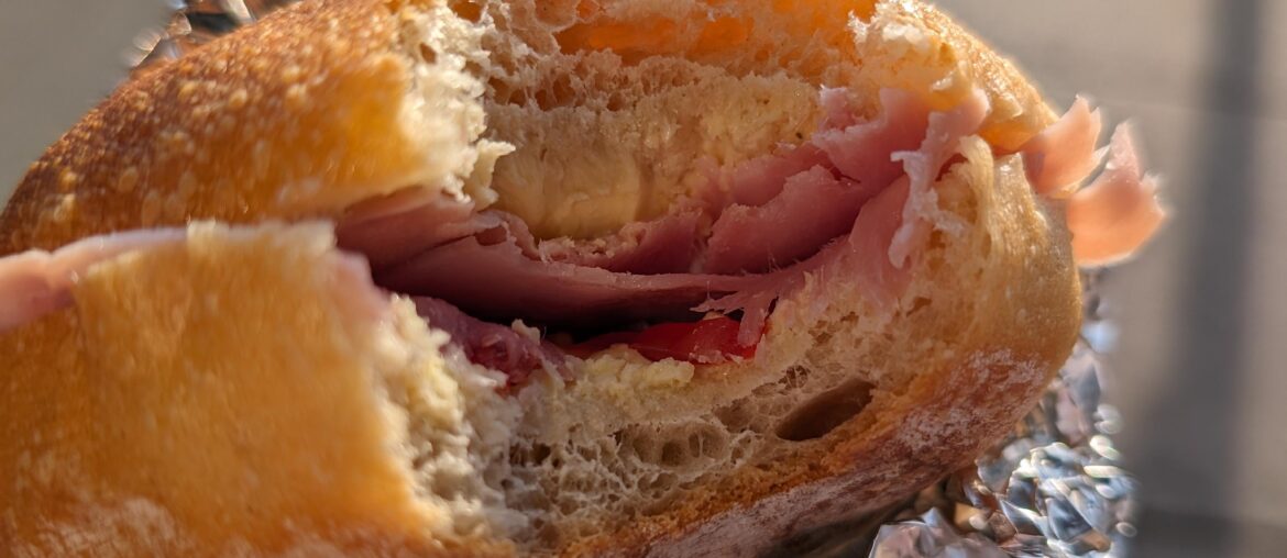 Homemade bread roll with cherry tomatoes and prosciutto cotto.