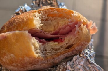 Homemade bread roll with cherry tomatoes and prosciutto cotto.