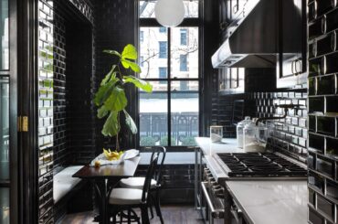 Apartment kitchen clad entirely in black tiles with an eat-in banquette, New York City [4800x6338]