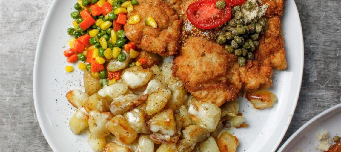 Pork Schnitzel topped with freshly grated horseradish & capers, served with butter sautéed vegetables & roasted potatoes w. Cream sauce