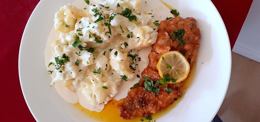 Breading chicken breast in parmesan cheese, lemon butter sauce and chilli.Cauliflower in cheese sauce