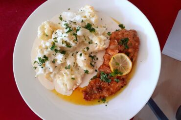 Breading chicken breast in parmesan cheese, lemon butter sauce and chilli.Cauliflower in cheese sauce