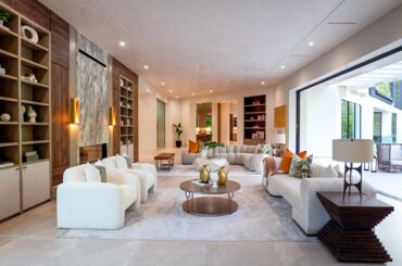 Massive Living Room With Built-Ins, Marble Fireplace, and Huge Floor to Ceiling Sliding Door Leading To Gorgeous Pool and Outdoor Space Located in Houston, Texas [3456×1944]