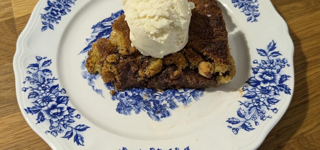 Cookie géant gianguja et noisettes grillées cuit dans une poêle en fonte