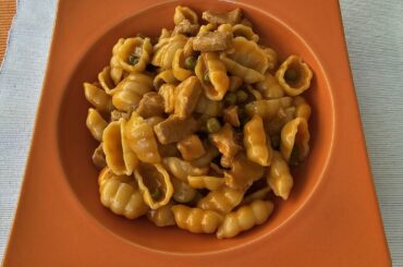 Pasta with small pieces of raw veal sausage meat rolled in potato flour, sautéed with onions, then cooked with tomato puree, peas, spices and plenty of white wine, flavoured with cream
