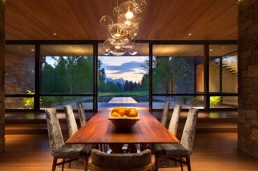 Sliding glass doors separate the dining area from a reflecting pool and the Wyoming wilderness | Wilson, WY [2364 x 1576]