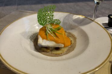 Oven-cooked cod filet with a black garlic cream, romesca (tomato-based Catalonian sauce) gratin, and potatoes.
