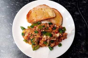 Scrambled eggs with bacon, onion, peppers and tomatoes