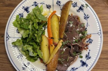 Venison in a red wine sauce with root vegetables and a basic salad