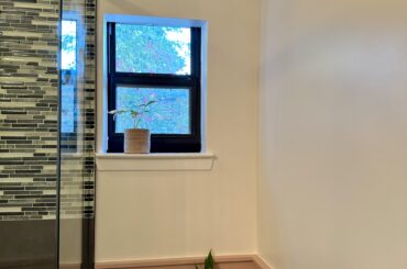 What do you envision for this bathroom wall with an off-center window?