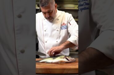 French chef cooks largemouth bass fish in his restaurant