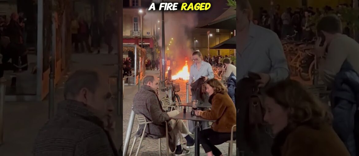 French Couple Dines Calmly While Protest Burns Outside French Couple Dines Calmly While Protest Burns Outside