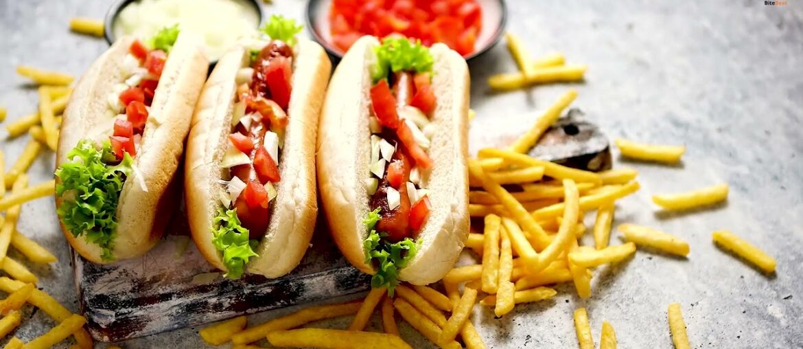 Delicious hot dogs and juicy burgers with crispy french fries arranged on a rustic wooden table Delicious hot dogs and juicy burgers with crispy french fries arranged on a rustic wooden table