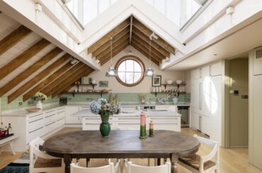 Marble countertop and teal tiled kitchen with a porthole window in a renovated three-bedroom duplex in a former Victorian dairy, North Kensington, west London, UK [2999x2000]