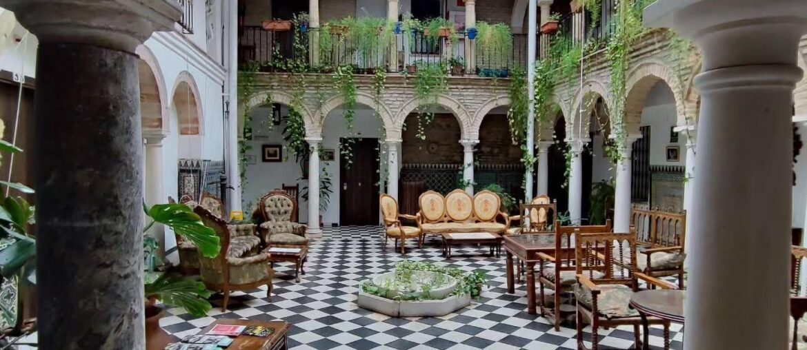 Covered courtyard lounge in Palacio del Corregidor, a former palace renovated and converted into a hostel in Córdoba, Andalusia, Spain [1440x1920]