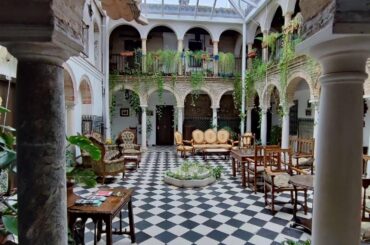 Covered courtyard lounge in Palacio del Corregidor, a former palace renovated and converted into a hostel in Córdoba, Andalusia, Spain [1440x1920]