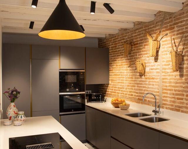 kitchen with exposed brick and sculptural lighting in a restored apartment, Barcelona Spain [640x899]