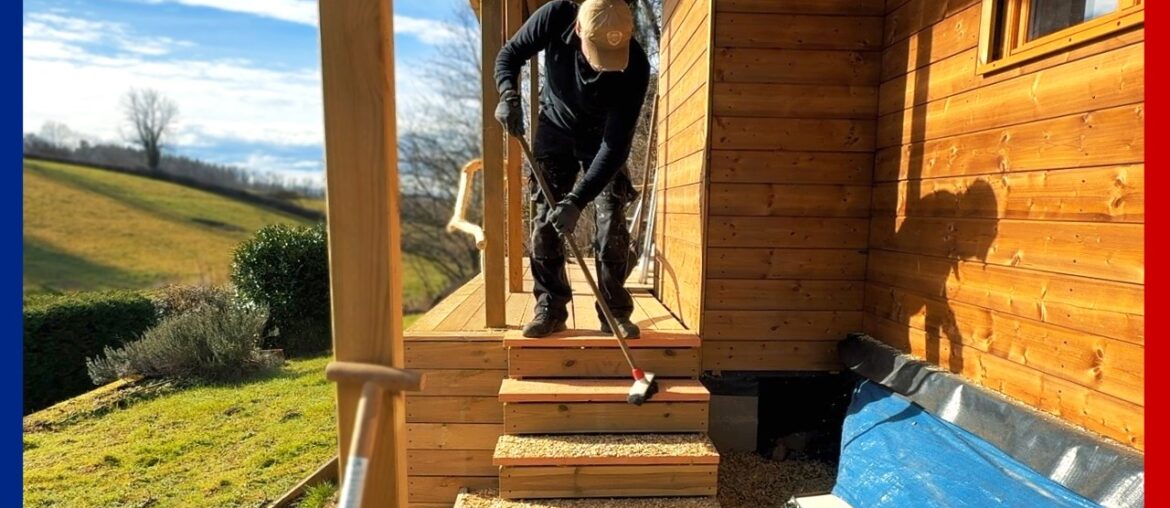 Een reling aan de vlonder van boomstammen en een trap maken voor het tiny house