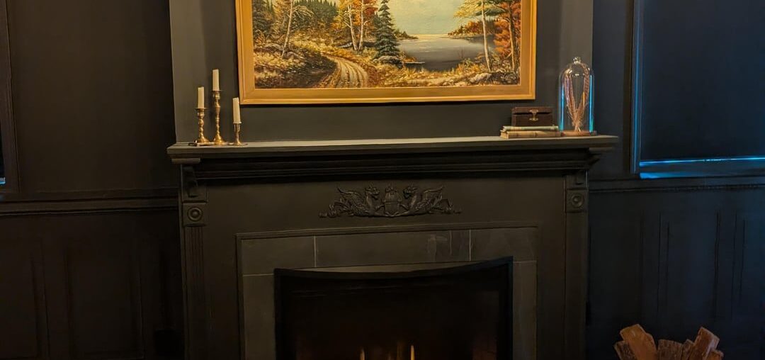 How does my mantle decor look? This is a basement area that has a dark academia/moody English traditional feel. Side note, I'm going to install the painting light lower than where it currently is.