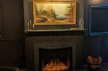How does my mantle decor look? This is a basement area that has a dark academia/moody English traditional feel. Side note, I'm going to install the painting light lower than where it currently is.