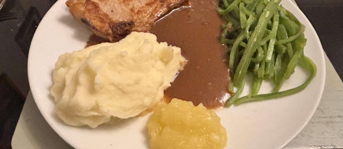 Pork chop with mash, runner beans and gravy with homemade apple sauce