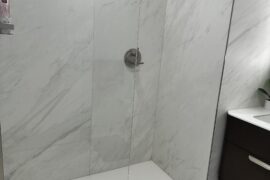 Shower glass door too short – constant water spill & floor flooding. Any neat DIY fixes (no major construction)?