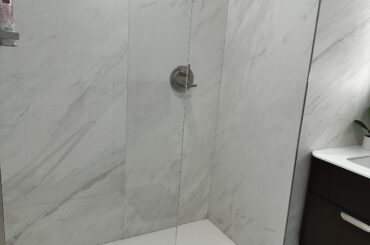 Shower glass door too short – constant water spill & floor flooding. Any neat DIY fixes (no major construction)?