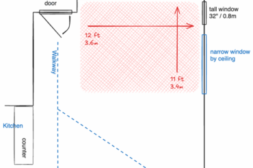 Corner space with windows, a TV, a couch, some kind of coffee table