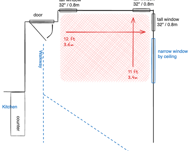 Corner space with windows, a TV, a couch, some kind of coffee table