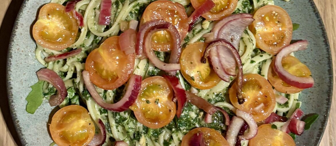 Spaghetti with a homemade pesto, rucola, roasted cherry tomatoes and red onions.
