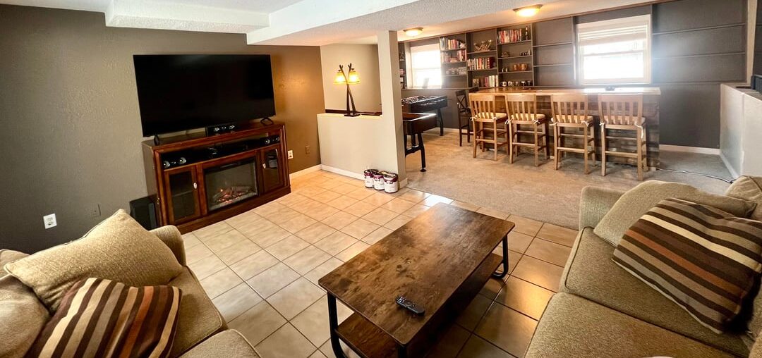 Refreshing my awkwardly shaped basement, aiming for a cozy cabin-style vibe. Still searching for a rug and would love suggestions on wall decor, lighting, and finishing touches.