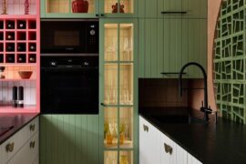 Eclectic kitchen featuring sage green and pink cabinetry with a terracotta feature wall, Barcelona, Spain [800x1067]