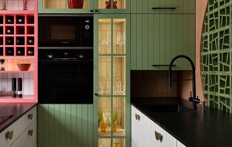 Eclectic kitchen featuring sage green and pink cabinetry with a terracotta feature wall, Barcelona, Spain [800x1067]