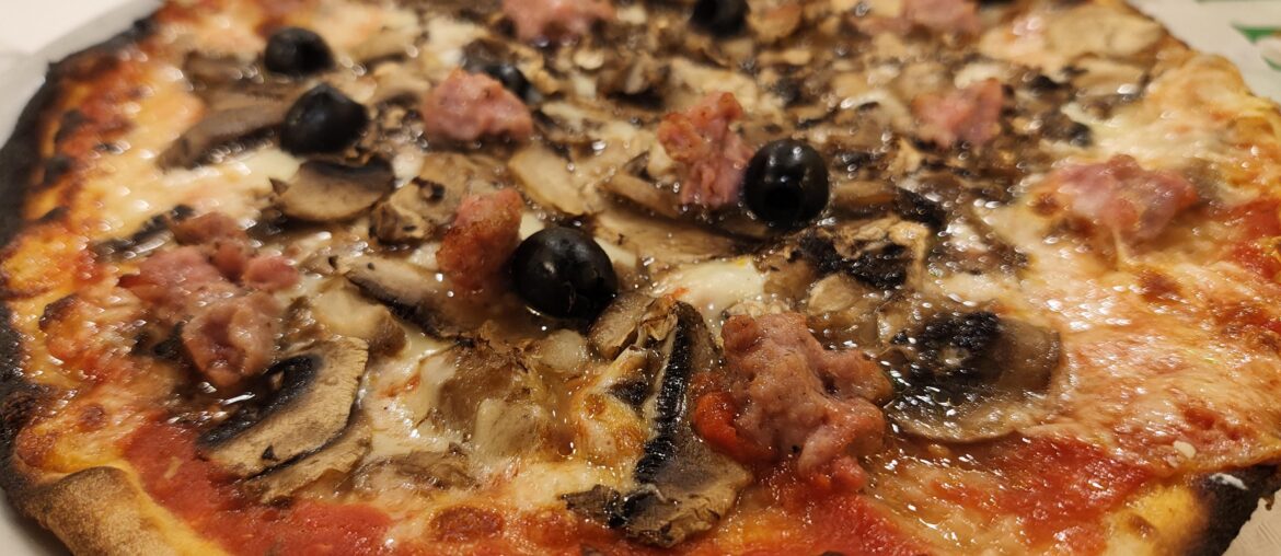 Pizza with mushrooms, salsiccia and olives, in Rome