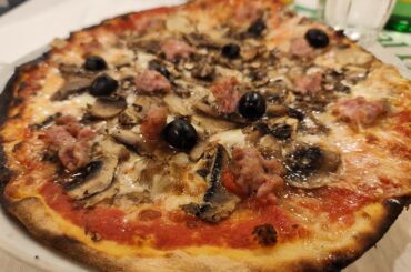 Pizza with mushrooms, salsiccia and olives, in Rome