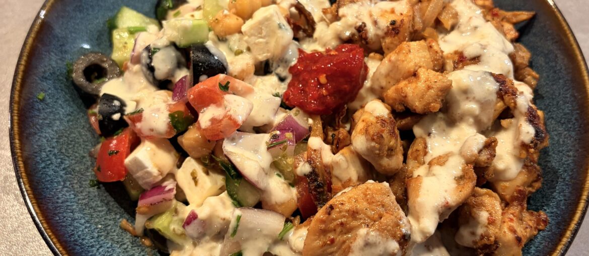 Greek salad with chickpeas, Middle Eastern spiced chicken, tahini sauce and spicy pepper paste
