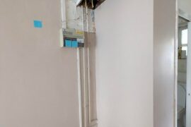 Please help- how to tastefully hide this ugly piping and circuit box in one corner of my flat?