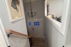 Help me make this stairwell/entryway feel less empty and more intentional — what would you add?