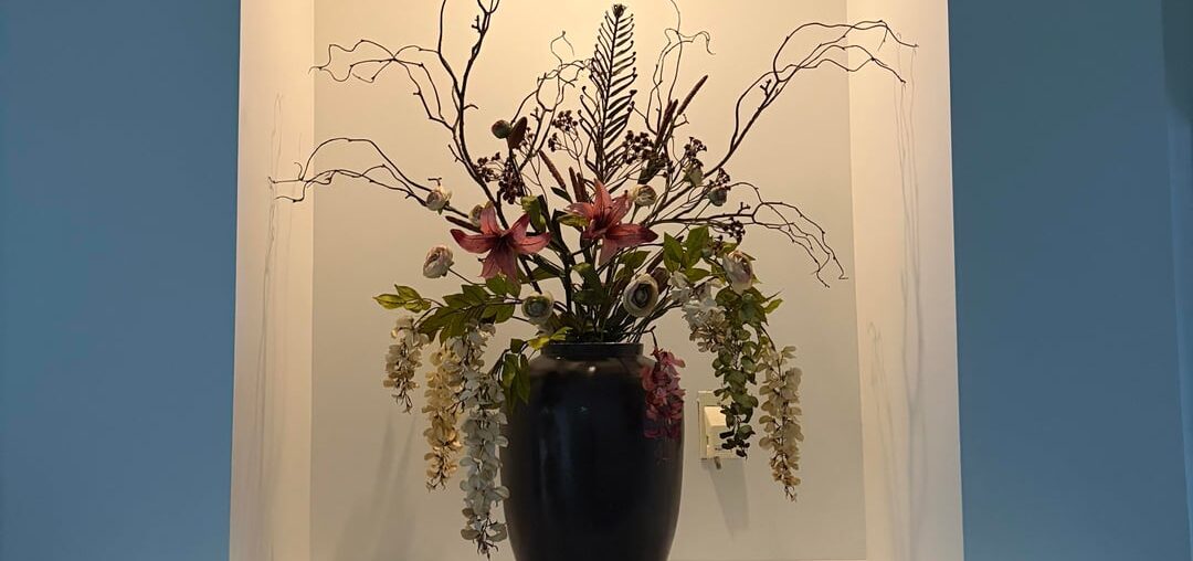 How can I style the rest of this niche/mantle? The arrangement is very large so I don’t want it to get over crowded but I think it needs a little something else? My color palette is deep browns, rusty browns, and beige. Accent color is like a rose taupe / light maroon.