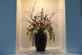 How can I style the rest of this niche/mantle? The arrangement is very large so I don’t want it to get over crowded but I think it needs a little something else? My color palette is deep browns, rusty browns, and beige. Accent color is like a rose taupe / light maroon.