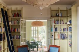 Library area with French Empire chairs around a circular antique table in a renovated old house, Sussex, England [1750x2362]