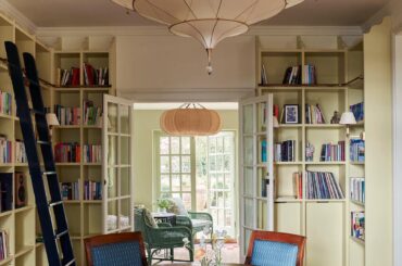 Library area with French Empire chairs around a circular antique table in a renovated old house, Sussex, England [1750x2362]
