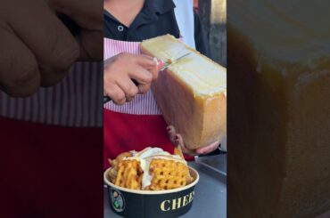 Melted Raclette Cheese being put on Waffle Fries